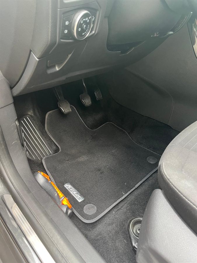 Voetenruimte bij de pedalen van een Ford Focus na reiniging: mat en tapijt schoon